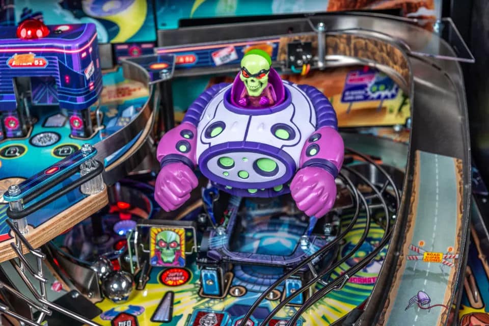 Colorful alien robot on intricate pinball machine with vibrant playfield