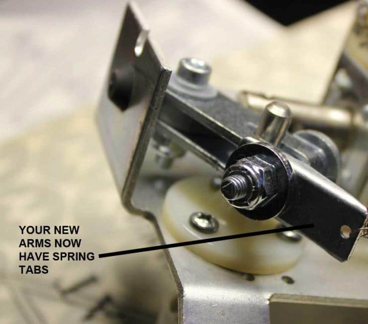 Mechanical component with spring tabs and bolts on a metallic surface