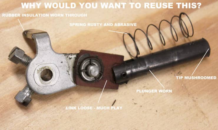 Worn mechanical tool with labeled parts showing signs of damage and wear