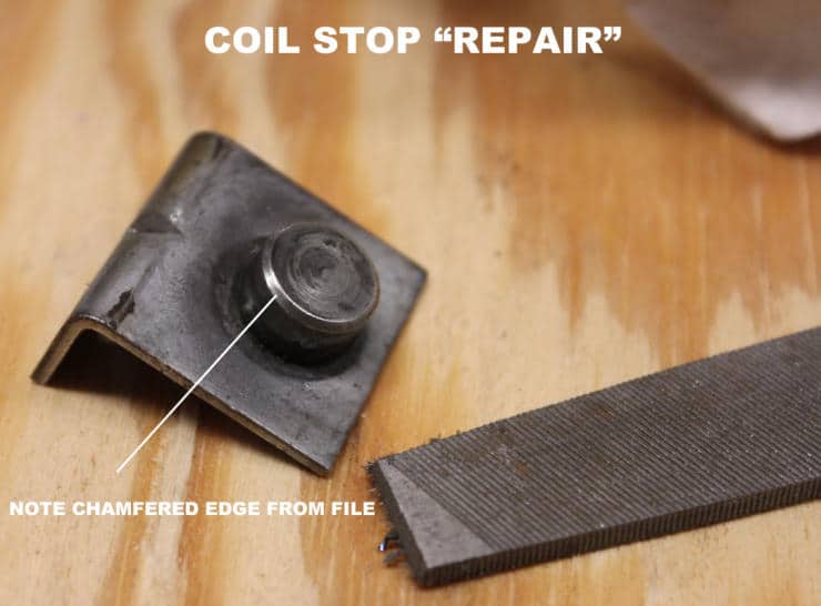 Metal coil stop repair with filed component on wooden surface