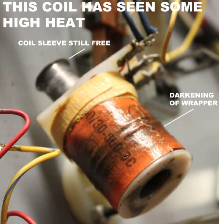 Damaged electrical coil with discolored wrapper and exposed sleeve