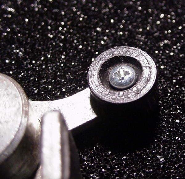 Metallic screw and washer on textured black sparkly background