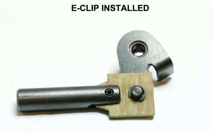 Metal and wooden mechanical component with e-clip showing precise assembly