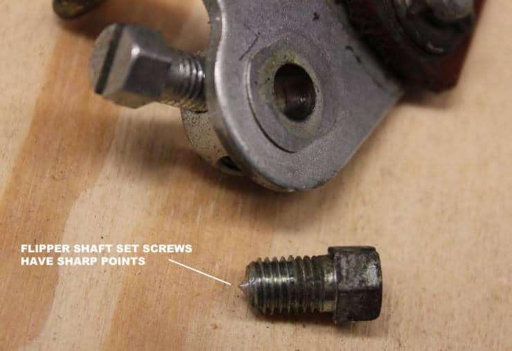 Metallic set screws with sharp points on wooden surface