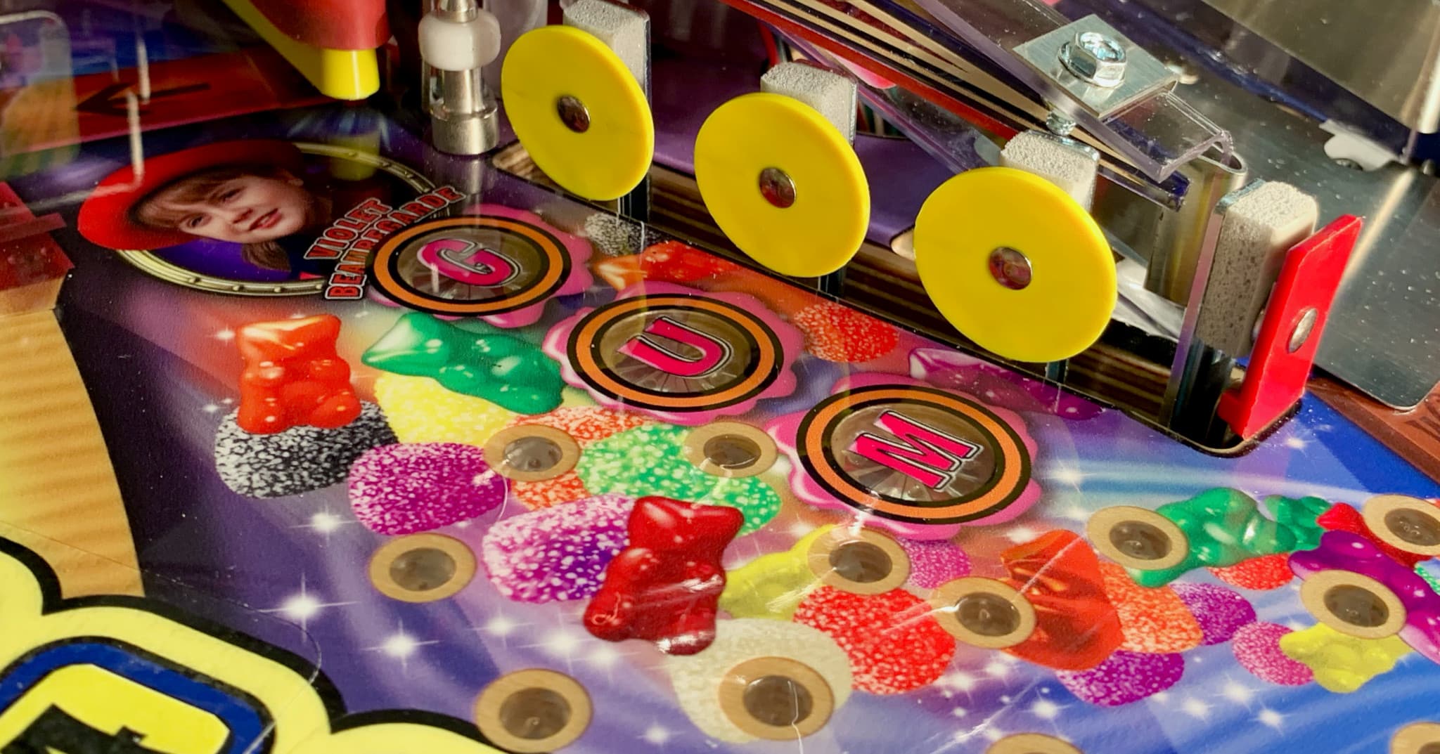 Colorful pinball machine with gummy bear-like bumpers and sparkly background