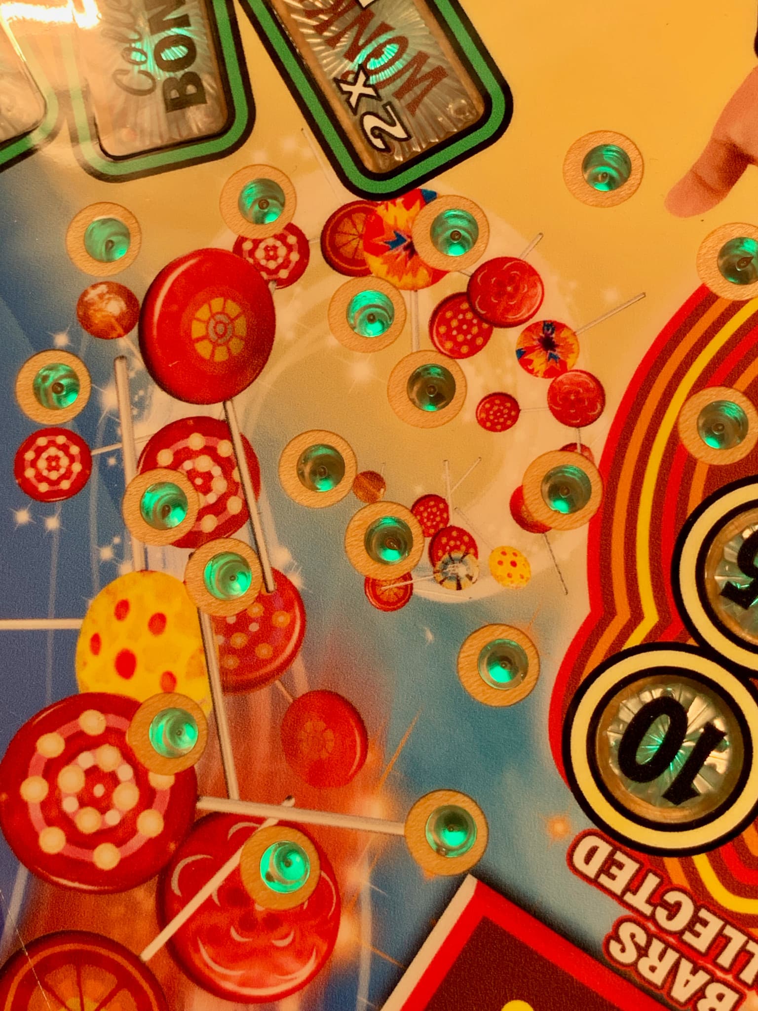 Colorful lollipops with green lights scattered on a vibrant background